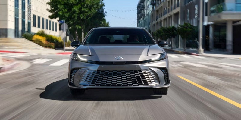 Front view of the 2026 Toyota Camry driving on a city street