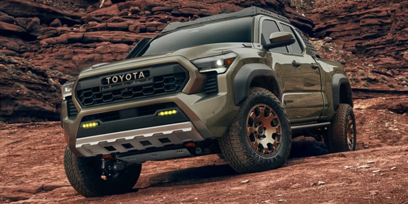 2026 Toyota Tacoma off-road driving on rocky desert terrain.